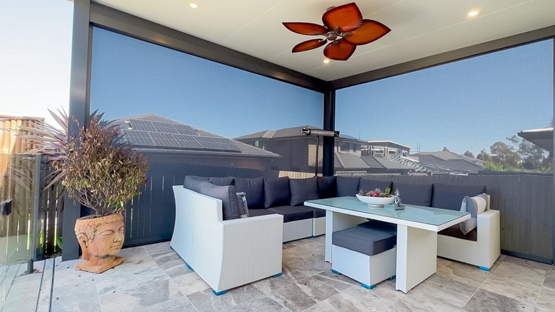 Stylish outdoor seating area under an insulated patio with Zipscreen outdoor blinds.